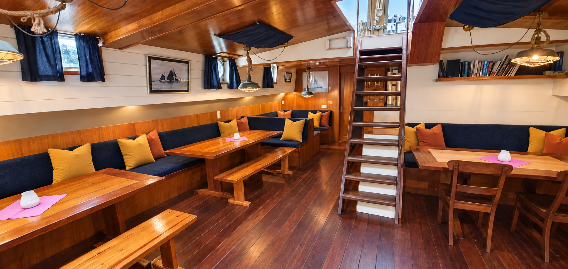 De warme salon van hotelschip Johanna Engelina met houten tafels en banken