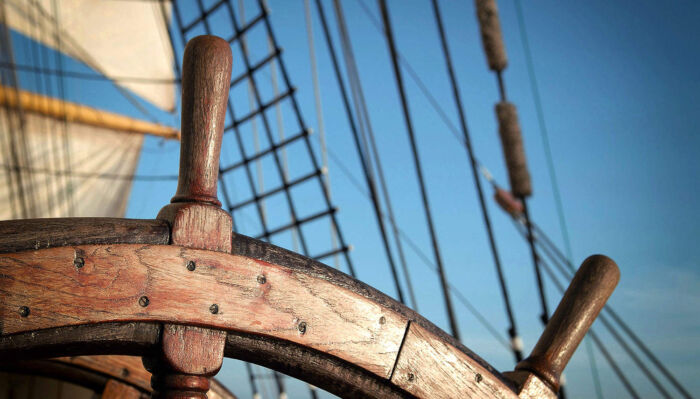 The ship's wheel against a clear blue sky