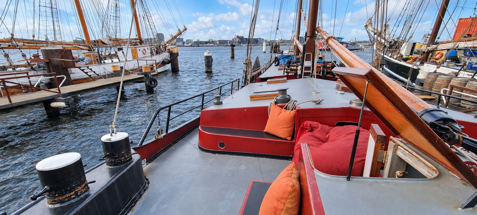 Zitbanken op het dek met uitzicht over het IJ en de skyline van Amsterdam